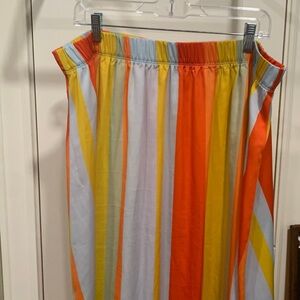 Loft strip midi length skirt with elastic waist. Side slits. Polyester fabric.